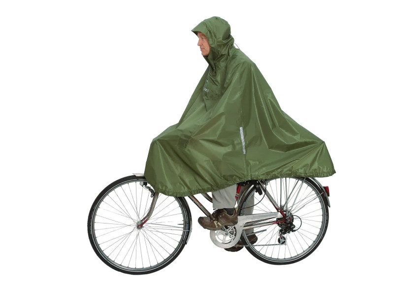 En mann sykler med regnponcho (grønn sykkelcape) til jobb
